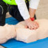 Female instructor showing CPR on training doll.