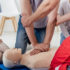 cropped view of group of people during first aid training with dummy